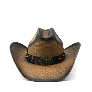 Detail of vintage straw cowboy hat with dark leather band and antique bull head buckle