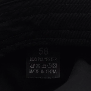 Detailed care label showing 100% polyester fabric material and size 58 for the beret hat