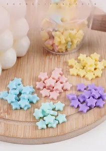 Vue détaillée de breloques étoiles en PVC coloré sur un plateau pour loisirs créatifs