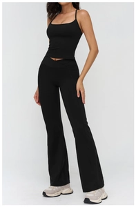 Close-up of black yoga set featuring thin strap sports bra and high-waist flared leggings