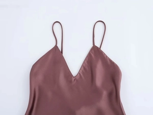 Detailed close-up of dark purple silk satin slip dress with deep V-neck and thin straps
