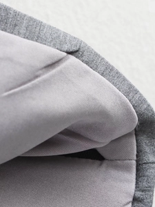Gros plan sur la texture du tissu en coton et lin gris et les coutures du haut cintré