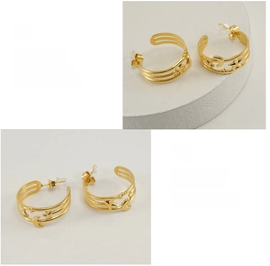 Detail view of 18K gold plated celestial C-shaped earrings with star and moon cutouts