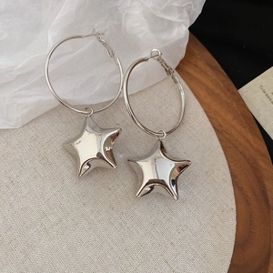 Dettaglio di orecchini a cerchio geometrici in argento con ciondoli a stella lucidi