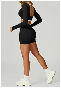 Detail of seamless black yoga set with open back long sleeve top and high waist shorts