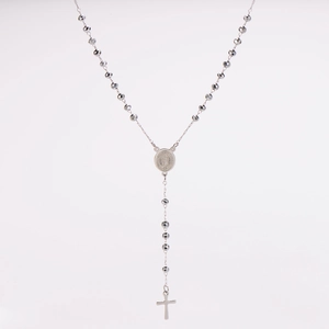 Macro shot of silver rosary necklace with faceted beads, holy medal and cross pendant