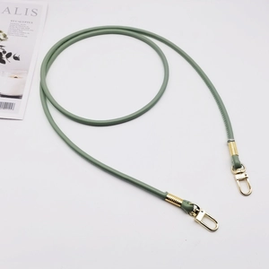 Close-up of green round PU leather shoulder strap with gold swivel lobster clasps