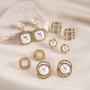 Detail of 6-pair gold earring set with faux pearls and rhinestones on silk