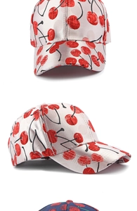 Close-up of cherry embroidery and satin texture on beige baseball cap details