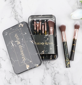 Detailed macro view of 8 marble texture makeup brushes with black storage tin