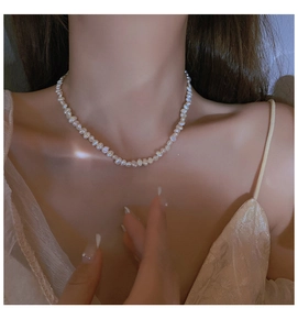 Close-up of elegant baroque freshwater pearl necklace worn on woman's neckline