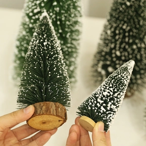 Snow-flocked mini cedar Christmas tree with natural wood base for table decor