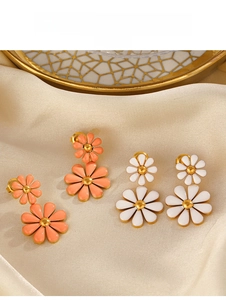 Detail of double-layer daisy drop earrings with orange and white enamel flowers