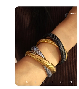 Close-up of tricolor gold silver and black snake bone Tubogas bracelets set on arm