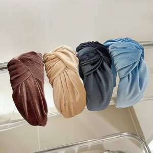 Close-up of four knotted corduroy headbands in coffee, beige, blue and grey colors