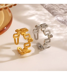 Macro detail of geometric hollow chain rings in gold and silver with adjustable opening
