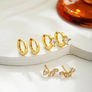 Macro shot of 18K gold earrings set featuring cubic zirconia studs and small hoop rings