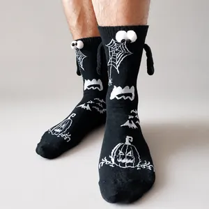 Close-up of funny Halloween socks with 3D eyes and magnetic hands in black cotton