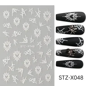 Macro detail of Halloween nail stickers with spider web patterns and black heart designs