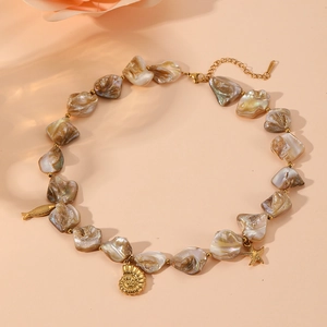 Detailed view of beach necklace with natural shell beads and gold sea life charms