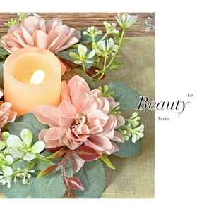 Macro detail of a pink dahlia candle wreath with LED candle on a rustic wooden table