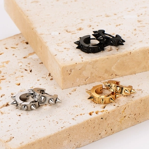 Three pairs of retro punk spike hoop earrings in black, silver, and gold metal finishes