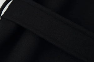 Close-up of elegant black wool fabric texture and reinforced double stitching detail