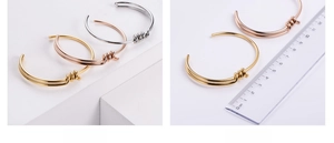 Detail of knot design on gold, rose gold and silver stainless steel bangles with size scale
