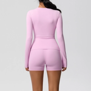 Vue arrière du haut de yoga rose à manches longues et du short de sport ajusté