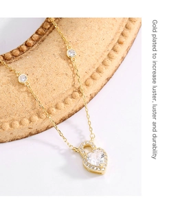 Detail view of gold-plated heart locket necklace with sparkling zircon stone setting