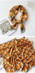 Detail of satin square scarf with orange and navy shell pattern and elegant grey border
