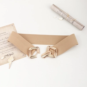 Détail d'une boucle dorée sur une large ceinture élastique kaki pour robe d'été