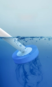 Macro view of disposable toilet brush head dissolving cleaning liquid in blue water