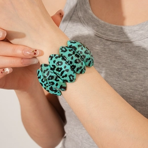 Close-up of leopard print resin bracelet with green segments and oval link pattern