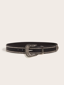 Detail of black punk belt featuring silver studs and vintage floral embossed buckle