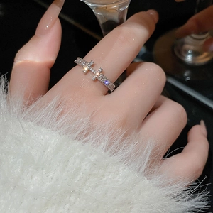 Silver-colored minimalist open ring with zircon heart design on a model's hand