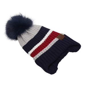 Close-up of winter striped knit hat with plush pom-pom and leather Super Star tag