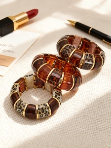 Detailed top view of leopard print resin bangles with gold spacers and tortoise texture