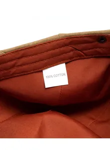 Close-up of 100% cotton inner lining with metal fastener and stitching on a beret cap