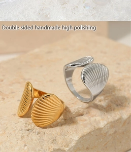 Macro shot of double-sided handmade polished fan-shaped shell rings on natural stone