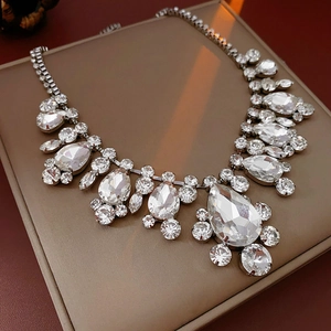Close-up of sparkling waterdrop and round rhinestones on a silver-plated geometric necklace