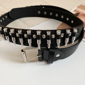 Détail de la ceinture en cuir noir avec rivets argentés et boucle métallique à ardillon