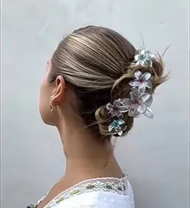 Floral resin hair claw clips with pink and blue gradient accents in a ponytail style