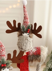 Close-up of a Christmas reindeer plush toy with a red knitted hat and soft furry texture