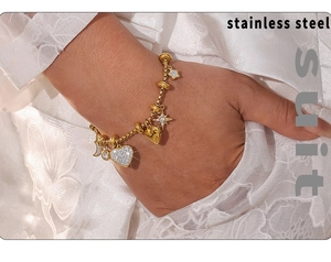 Macro shot of gold stainless steel bracelet with zircon star, heart and moon charms