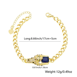 Detail view of gold Cuban chain bracelet featuring a leopard head biting a blue gemstone