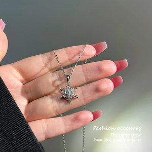 Detail of silver snowflake pendant with clear cubic zirconia on a delicate O-chain