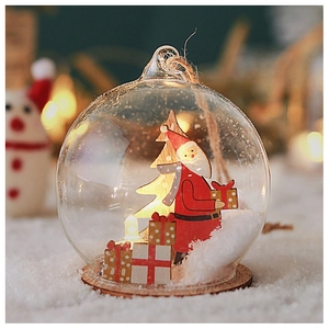 Close-up of a glass Christmas ball with Santa, wooden base and warm LED lighting