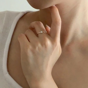 Detail of silver S925 heart ring with square zircon worn on a woman finger