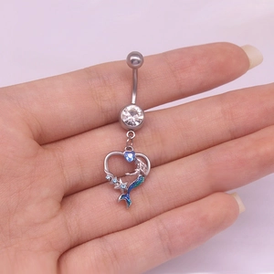Détail d'un piercing de nombril en argent avec pendentif sirène en forme de cœur